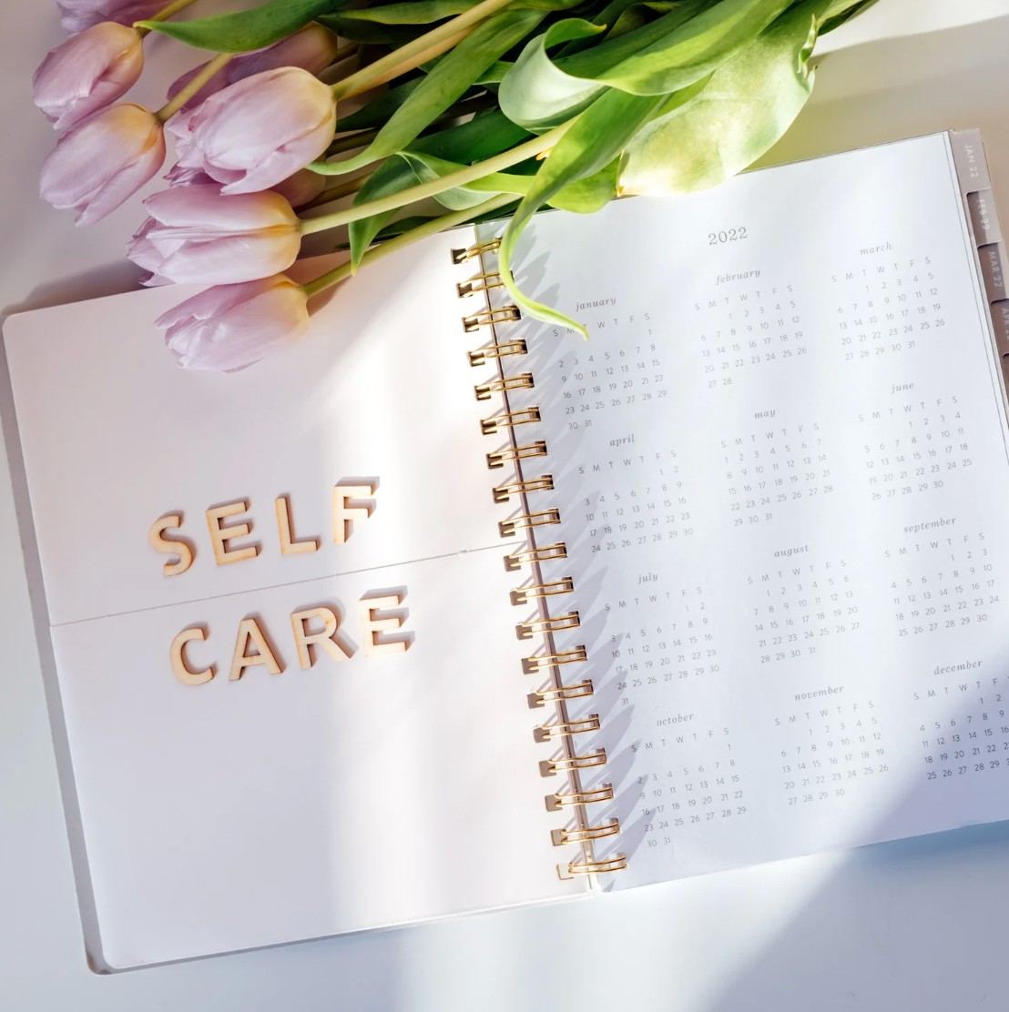 花と手帳に添えられたSELF CAREの文字